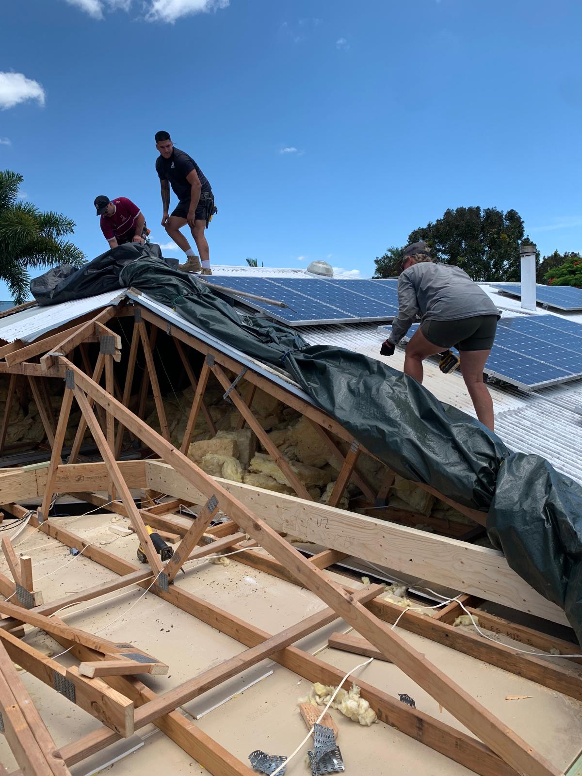Stacey working with the building team on a roof renovation